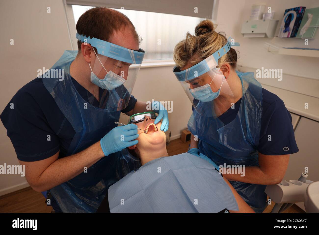 Dentist Dr. Allan Clarke and Dental Nurse Lynsey Galaway (right) wearing PPE with fellow dentist
