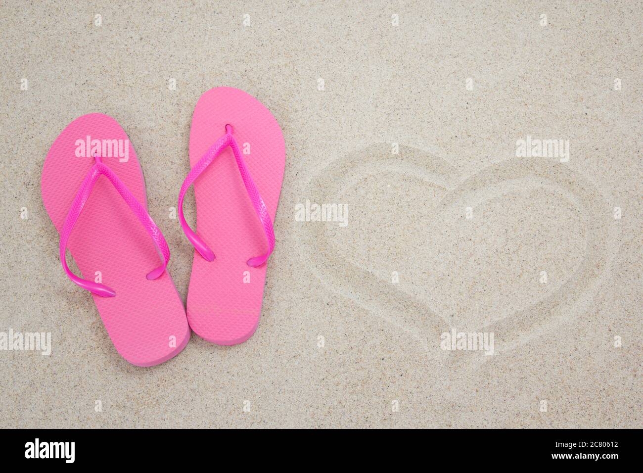pink flip flops and heart on white beach sand Stock Photo - Alamy