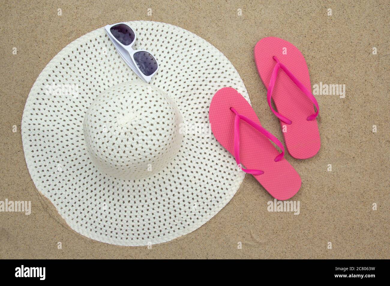 pink flip flops, sunglasses and white hat on sandy beach Stock Photo ...