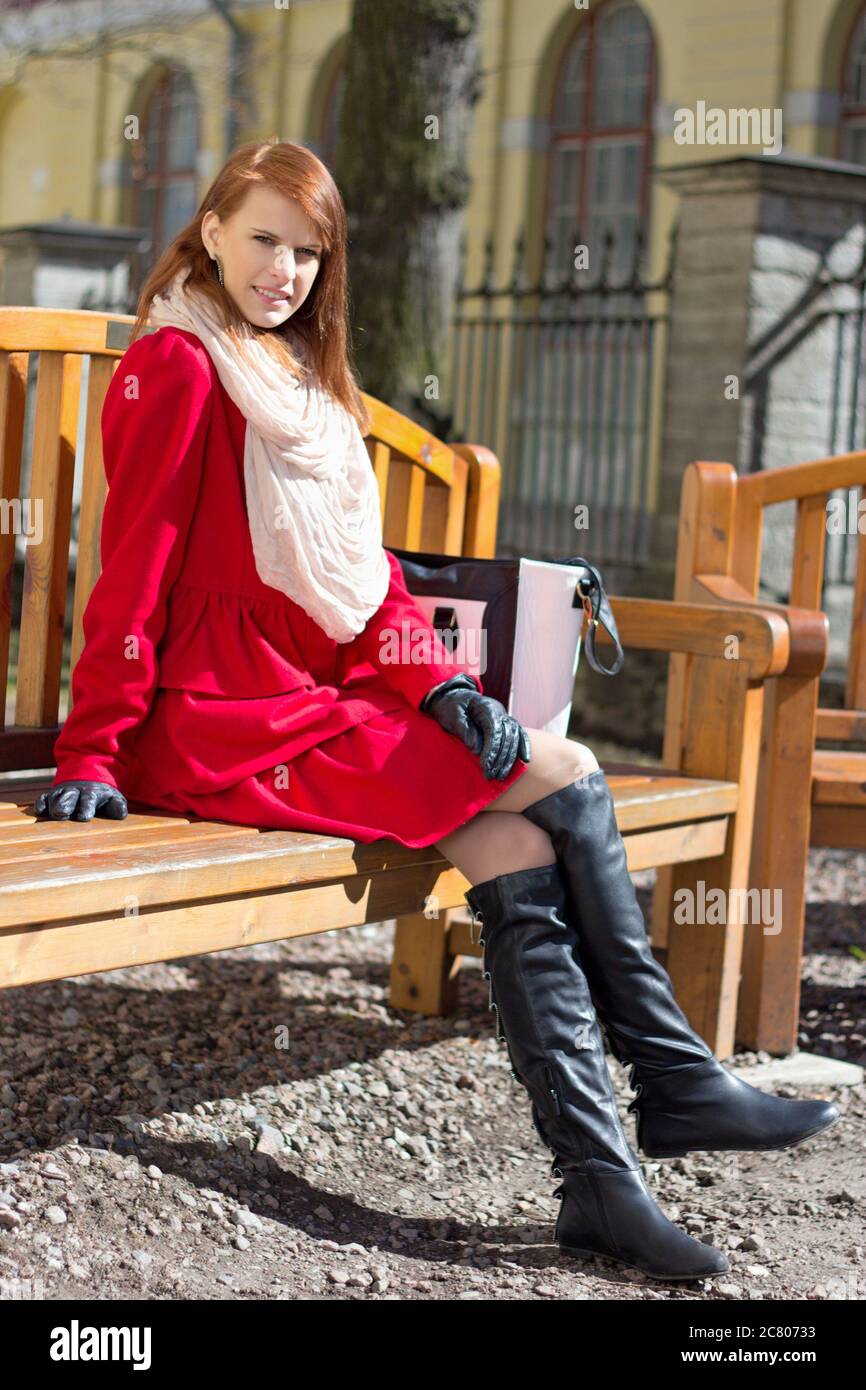 young beautiful redhaired woman crossing sitting on the bench Stock ...