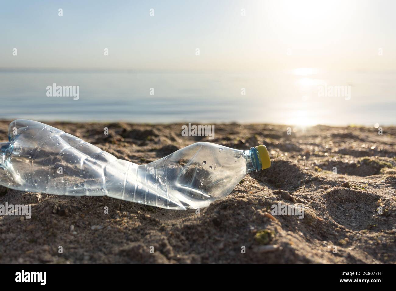 Wasted Single-Use Plastic Bottle Lying On Beach Polluting Environment Outdoors Stock Photo