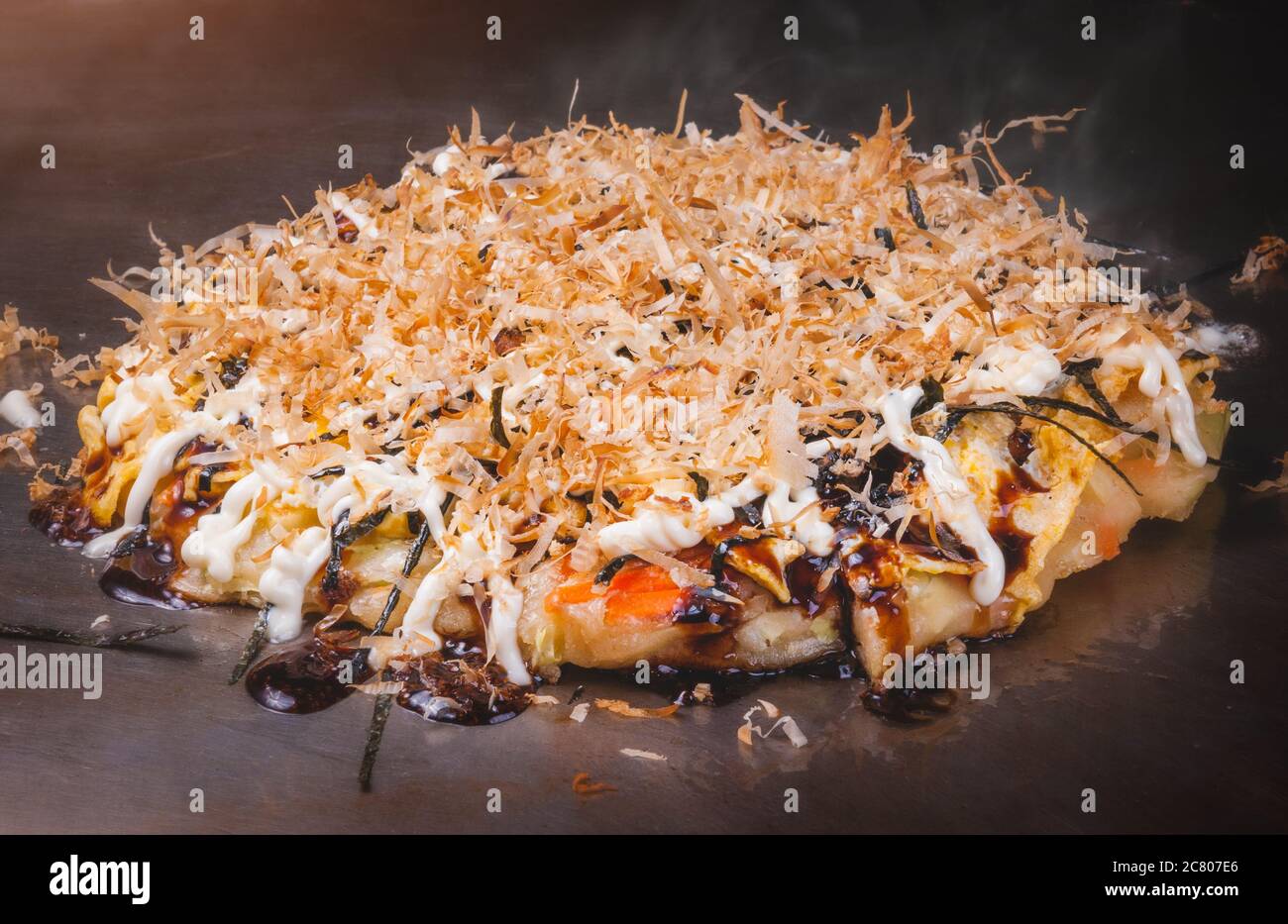 Japanese pizza okonomiyaki cooking on hot plate teppanyaki style Stock