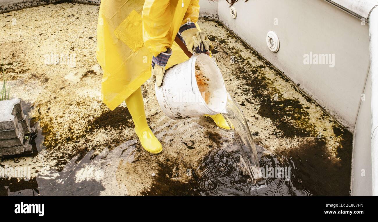Worker with a bucket of water in a muddy swimming pool Stock Photo Alamy