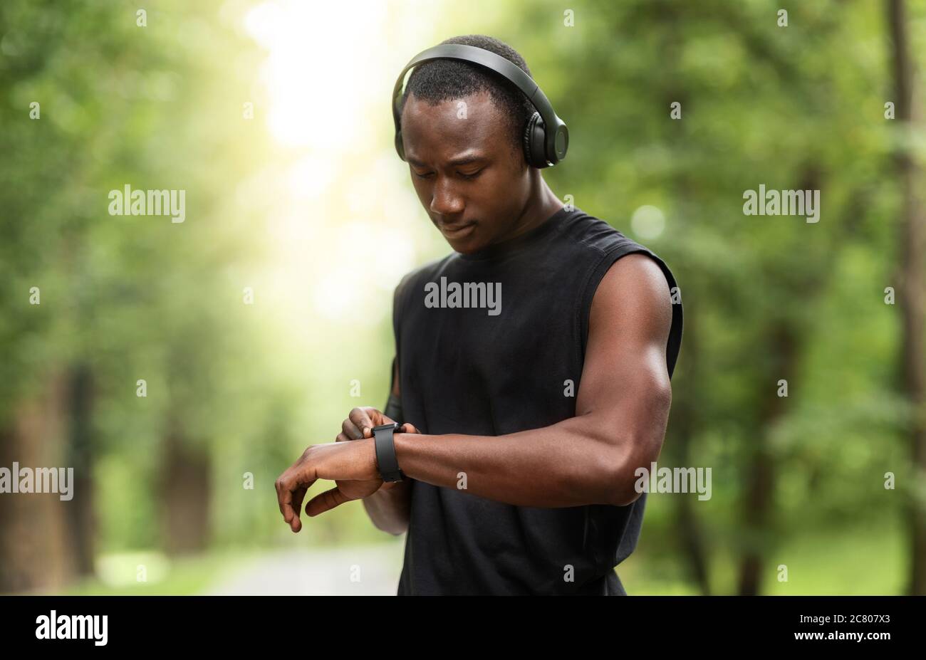 Black athletic guy working out with fitness bracelet Stock Photo