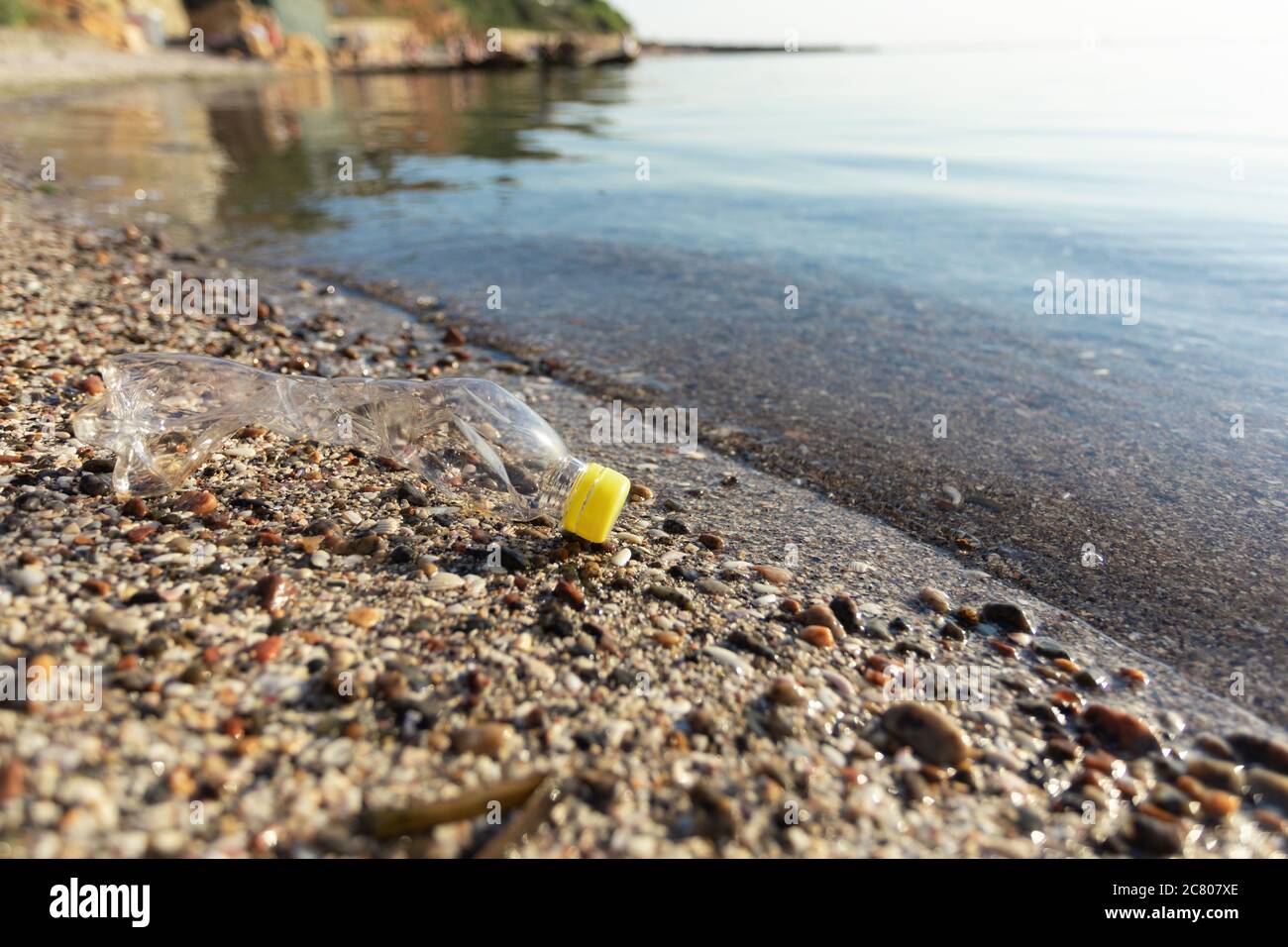 Wasted Plastic Bottle Lying On Sand Near Water, Blank Space Stock Photo