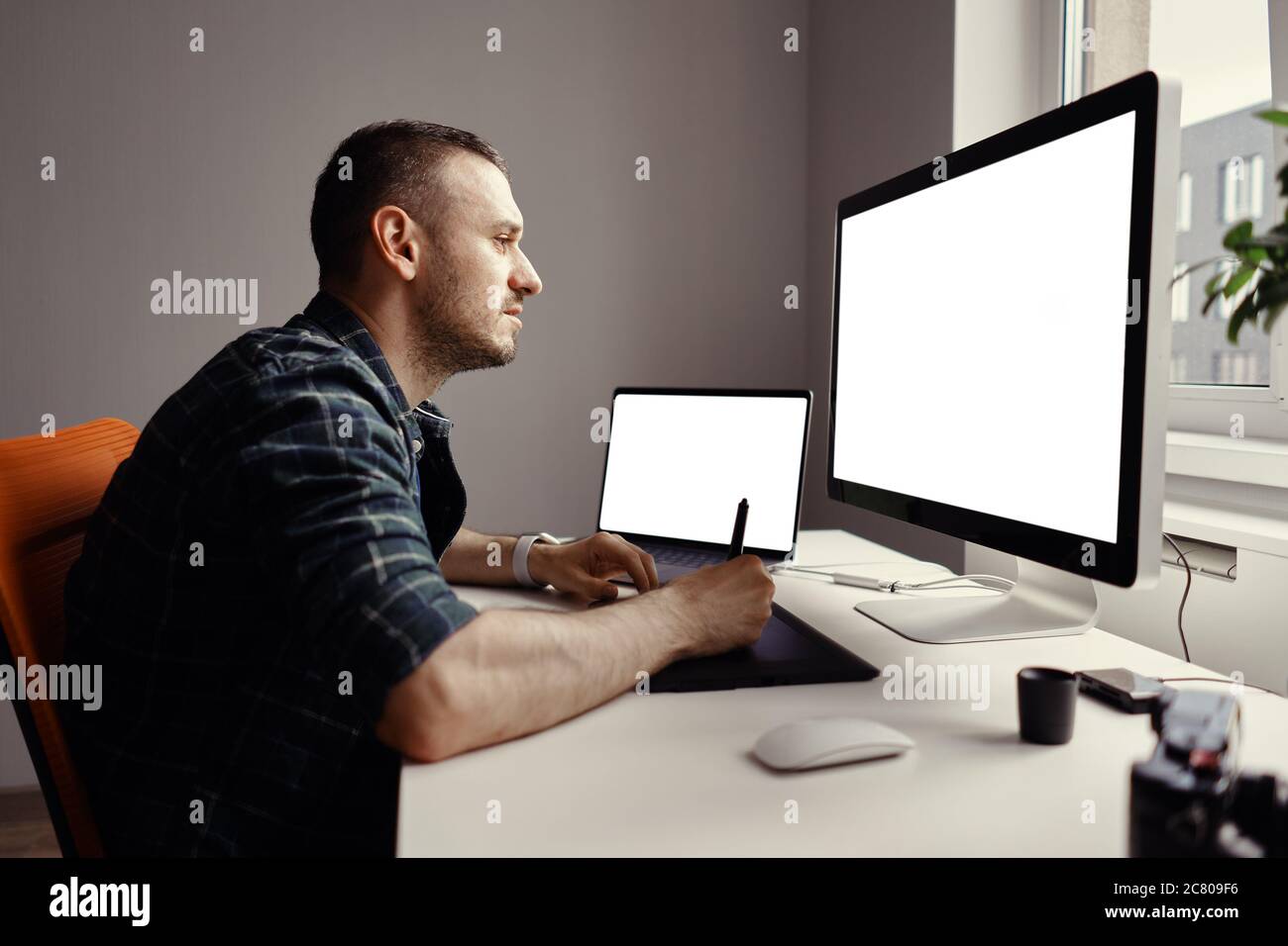 Graphic Designer working with interactive pen display, digital Drawing tablet and Pen on a computer with blank monitor Stock Photo