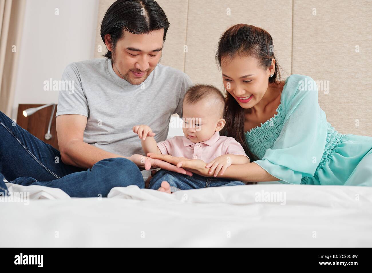 Curious little Vietnamese boy pointing at palms of his mother and ...