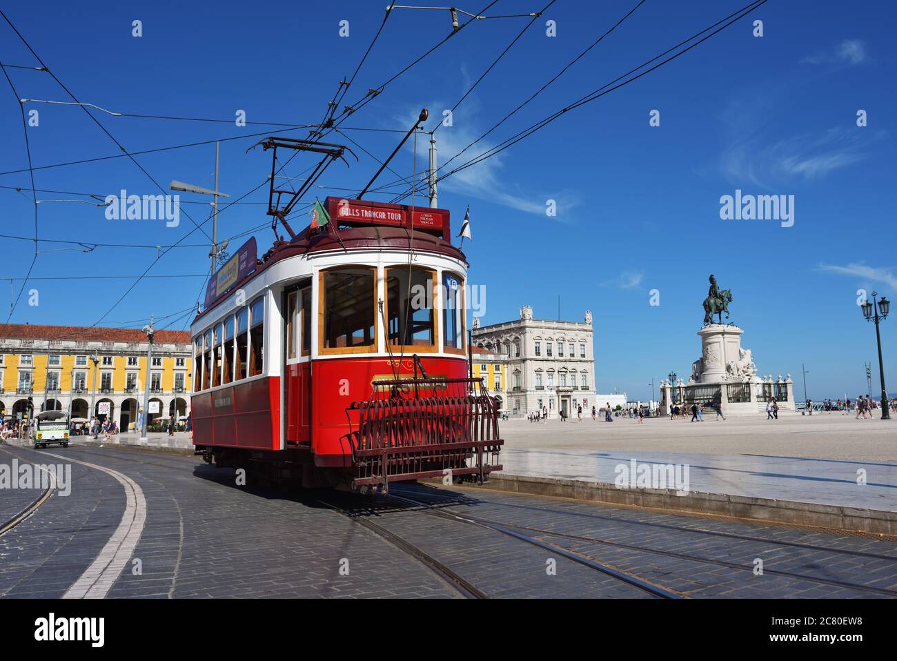 LISBON, PORTUGAL – June 11, 2017: Vintage red tram shown on the square Praca de Comercio (Commerce square), equestrian statue of King Jose on backgrou Stock Photo