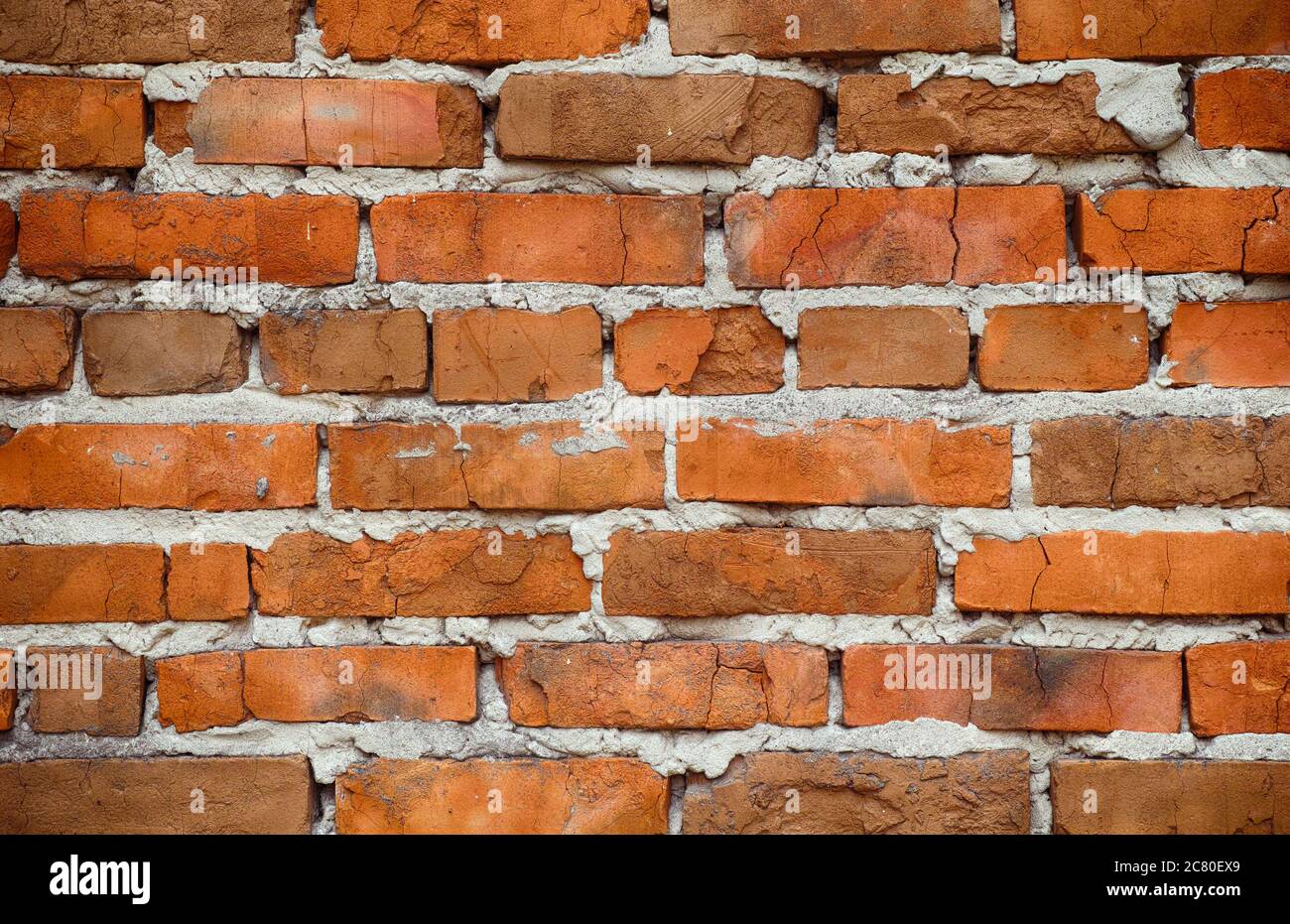An old red brick wall with cracks. Close up. Stock Photo