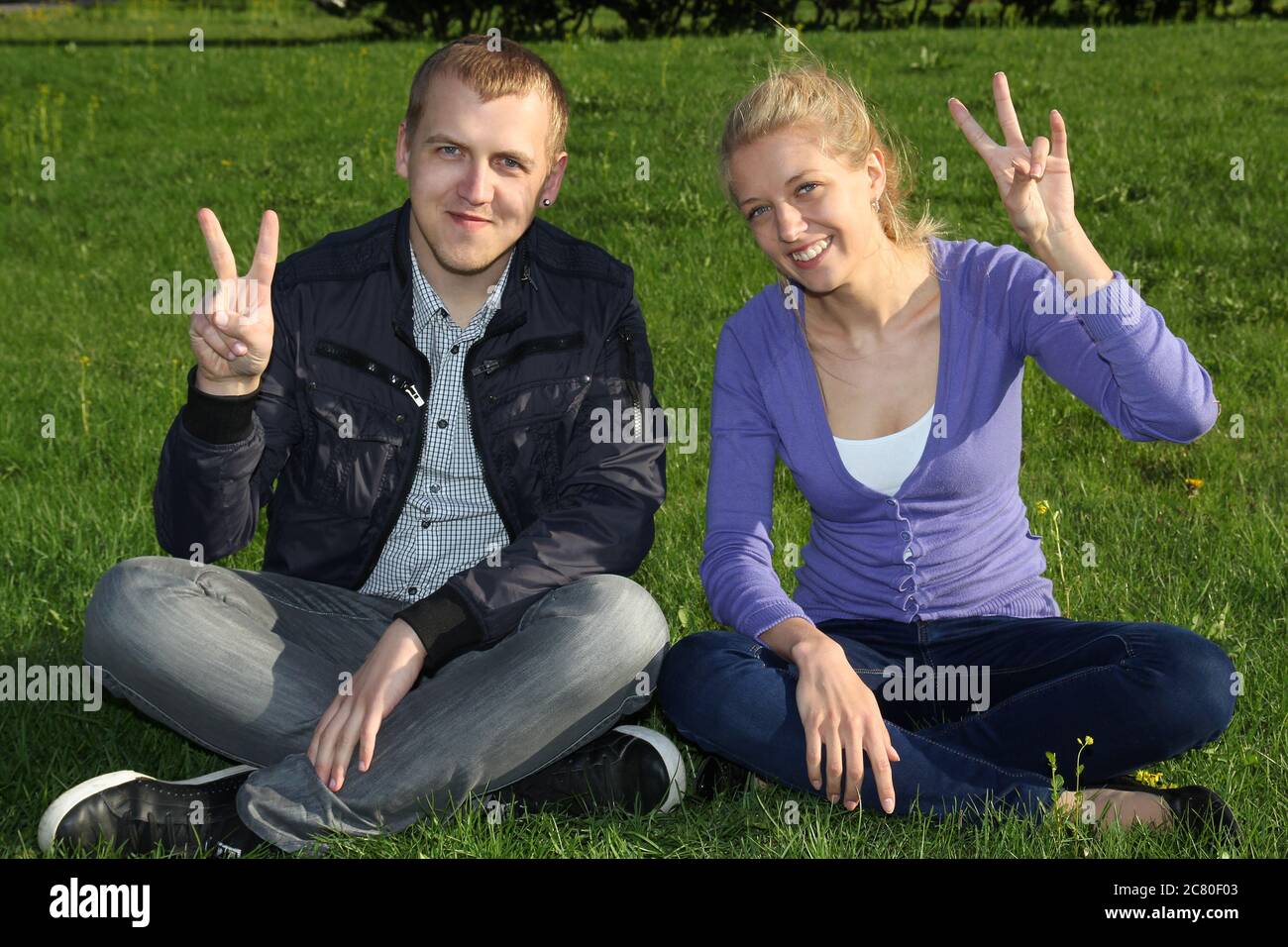 Woman and man showing victory sign in outdoor Stock Photo - Alamy