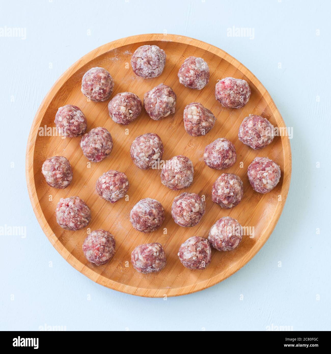 Raw meatballs on a wooden plate. Top view Stock Photo