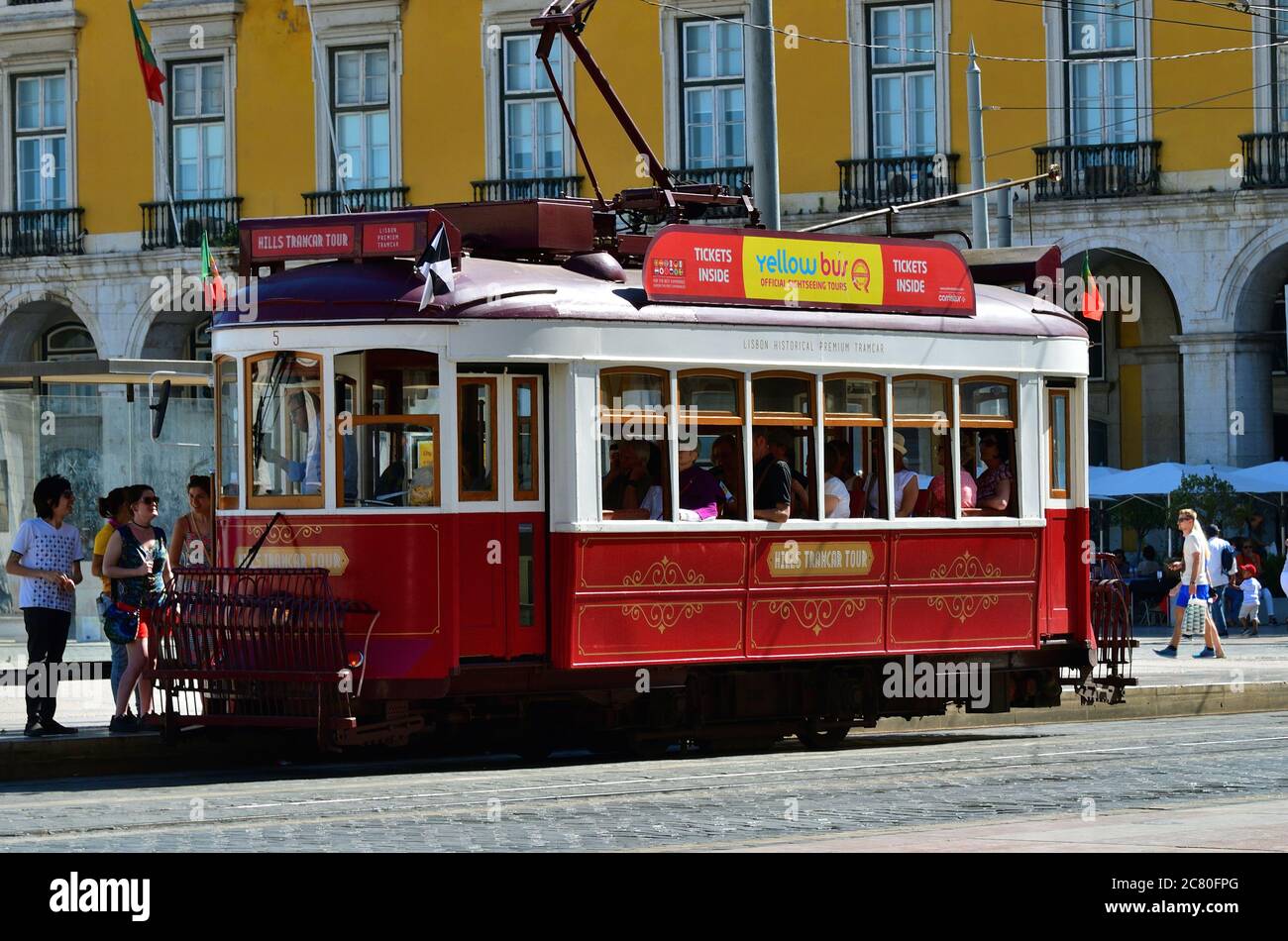 LISBON, PORTUGAL – June 11, 2017: People stand in line to get on vintage red tram on the square Praca de Comercio Stock Photo