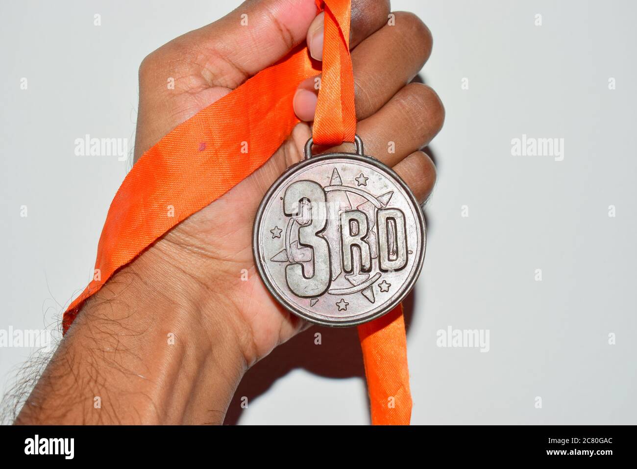 human hand holding a bronze medal close up Stock Photo