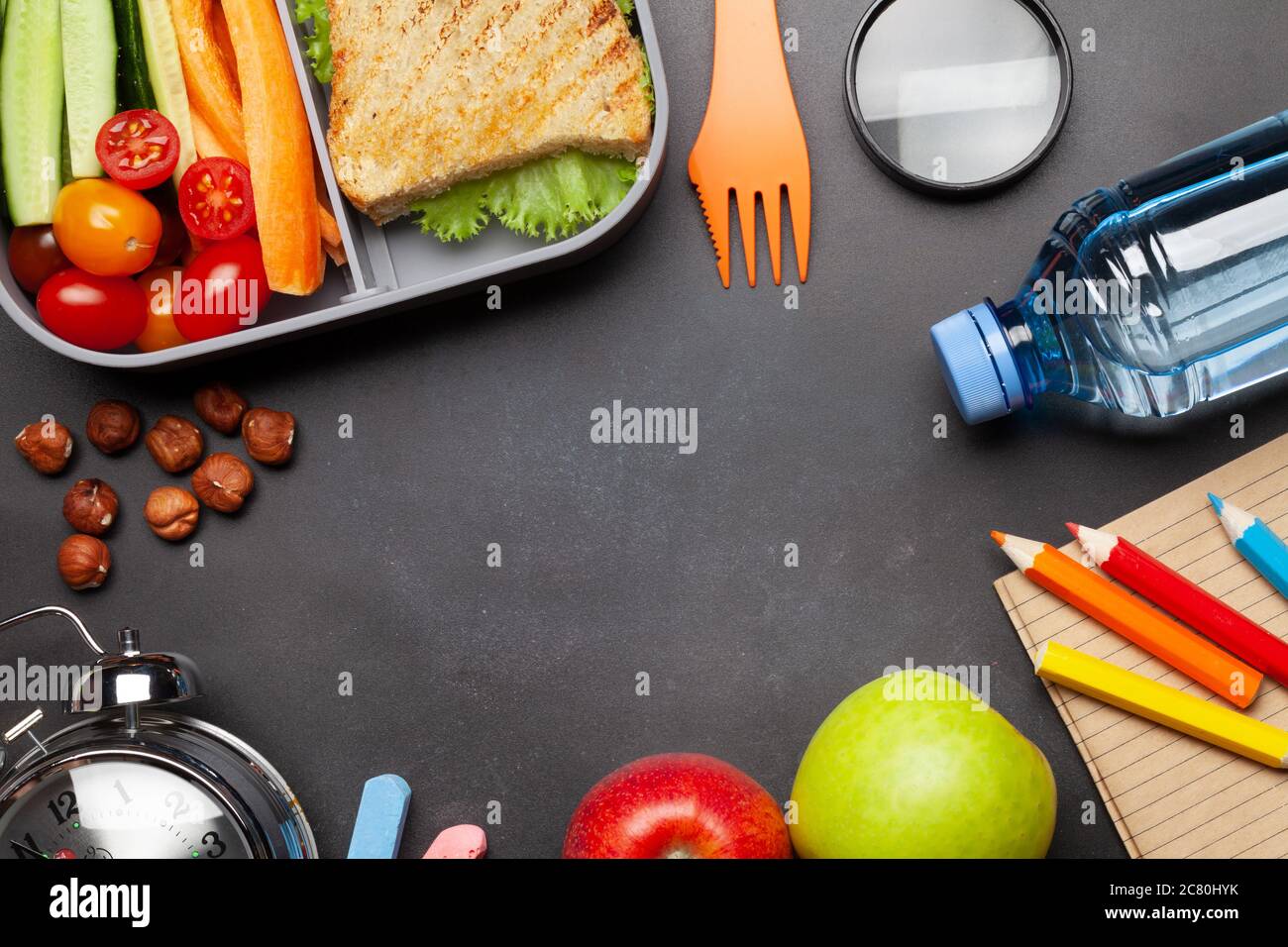 School lunch box and education stationery on stone table. Top view with ...