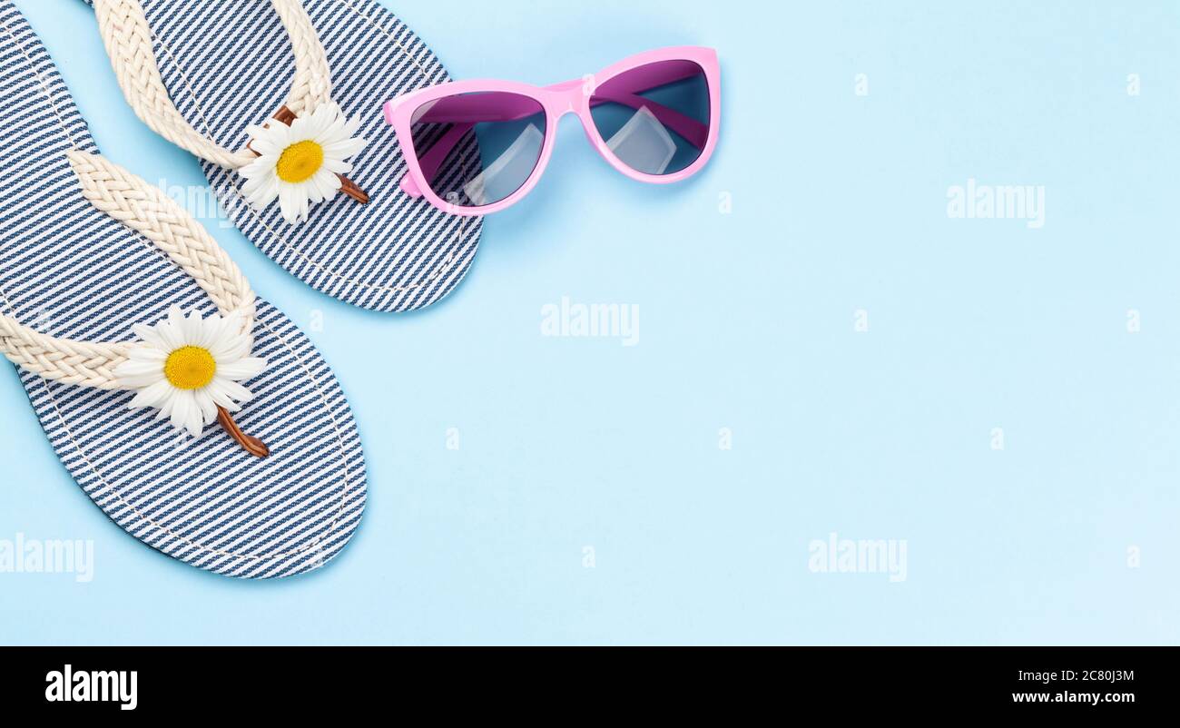 Beach flip flops with flowers and sunglasses on blue background. Summer ...