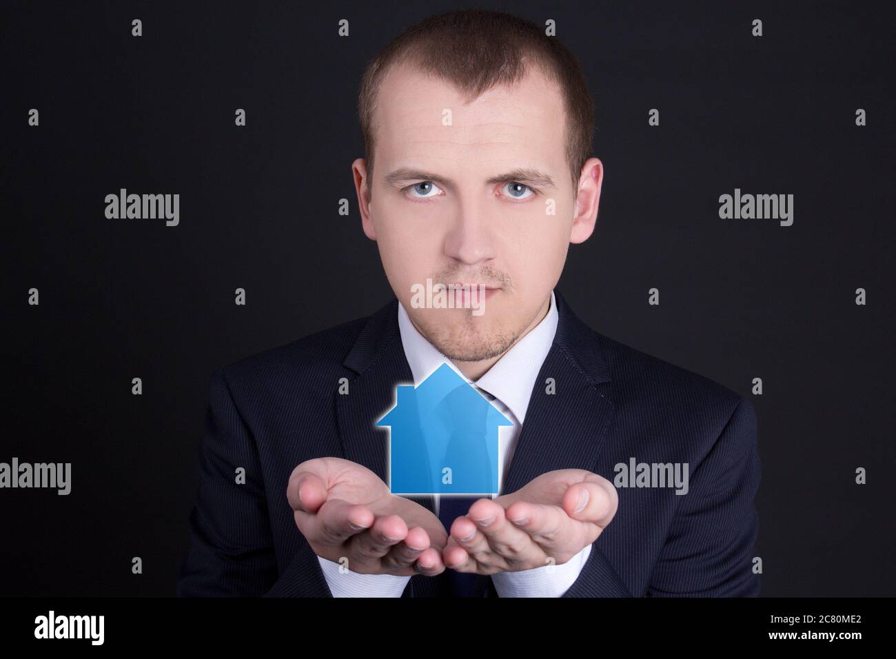 real estate concept - young handsome man holding small house in his ...