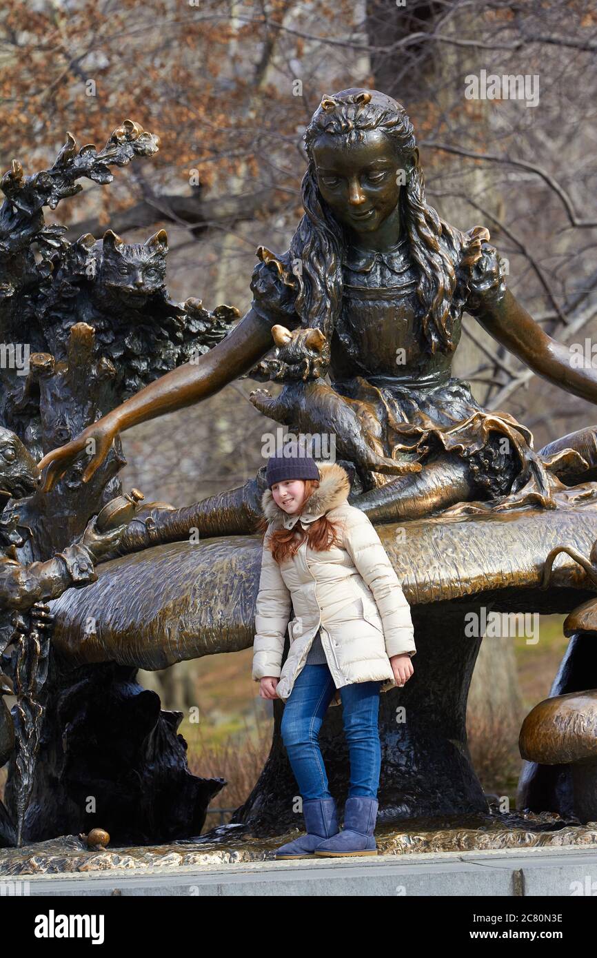 Young Girl Standing By A Statue in Central Park, New York City, USA