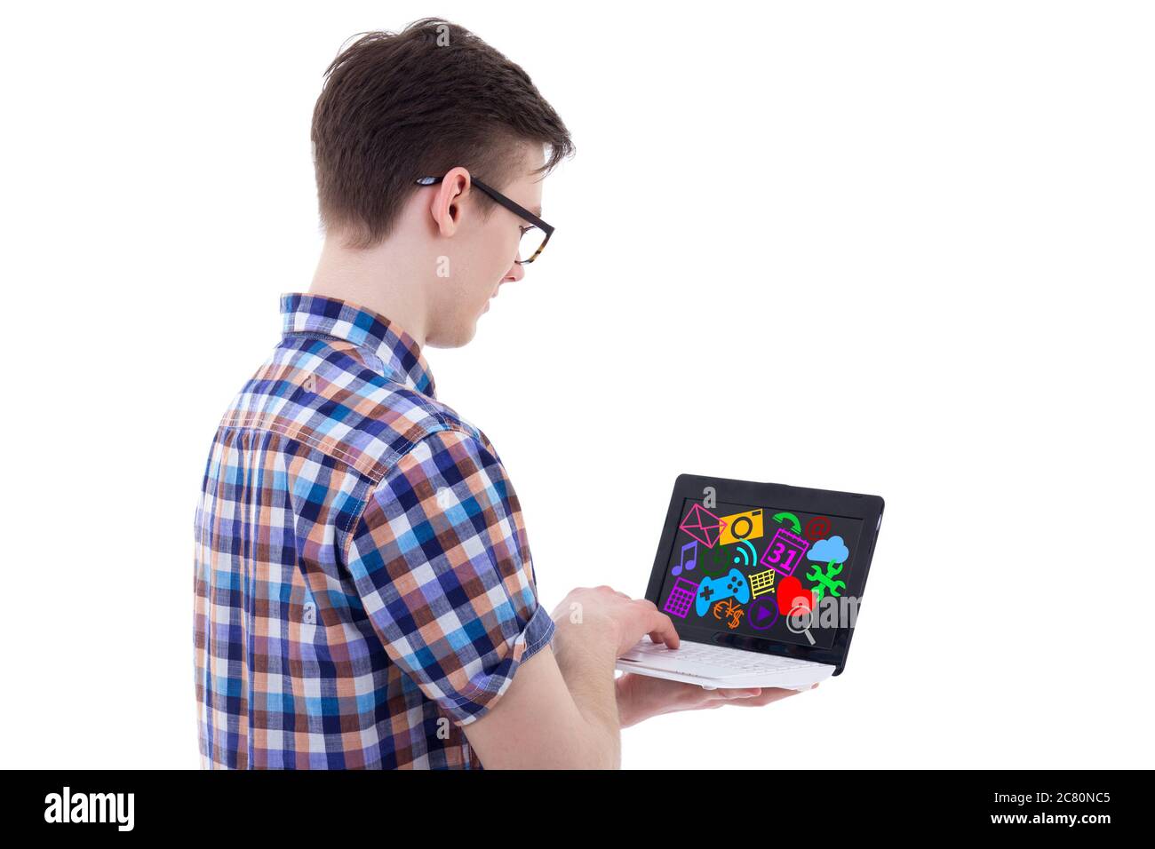 back view of teenage boy using laptop with media icons and applications ...