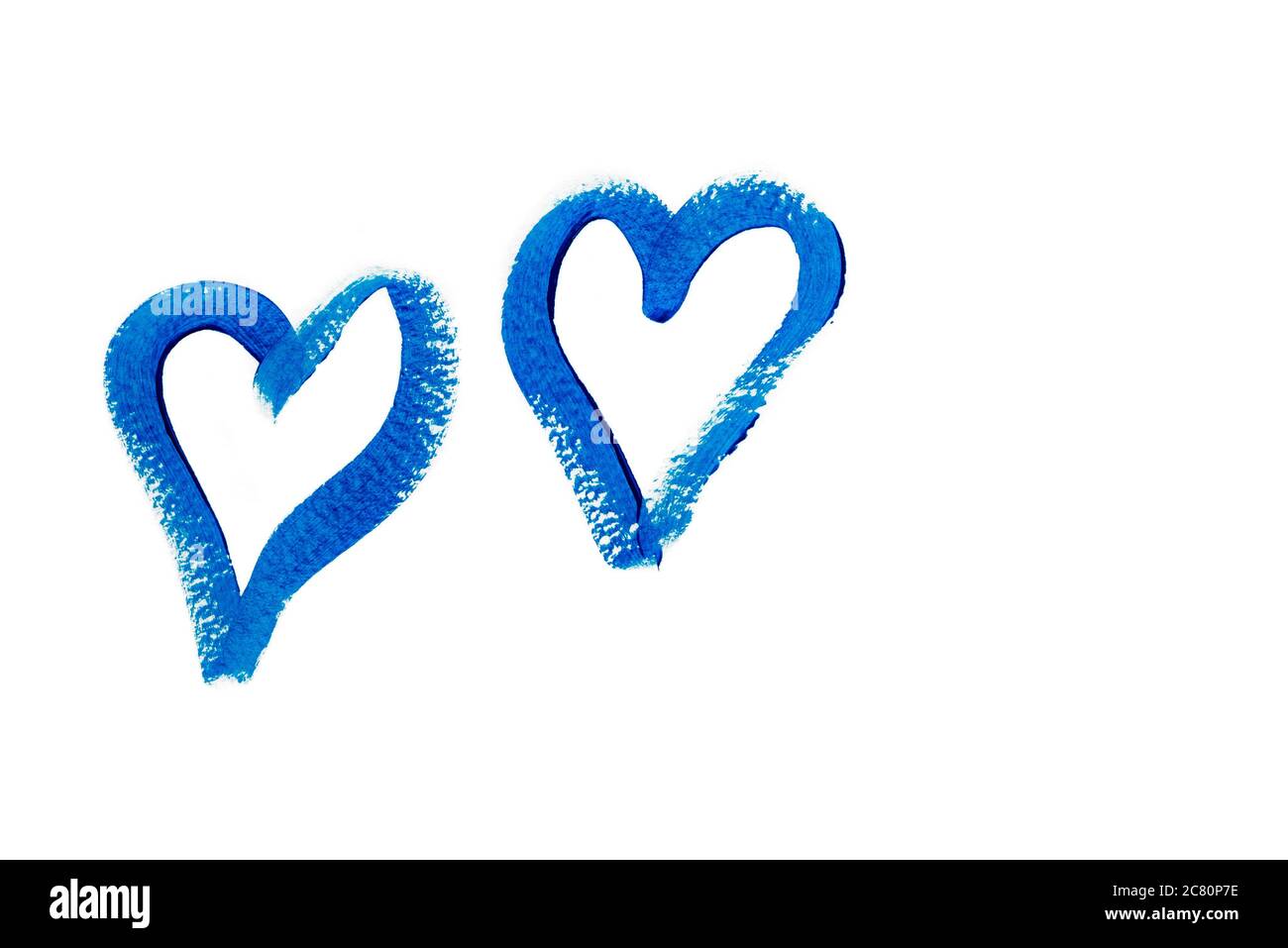 Two blue hearts hand drawn with acrylic paint isolated on white background. Valentines day background. Love symbol. Trendy classic blue color. Closeup Stock Photo