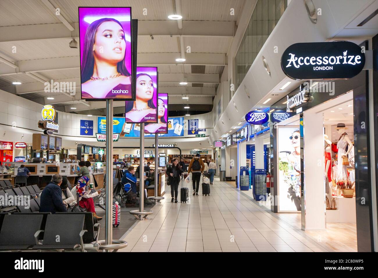 Interior of the departure lounge at Stansted airport in London. Seating  area outside various shops including Accessorize and Boots and others Stock  Photo - Alamy