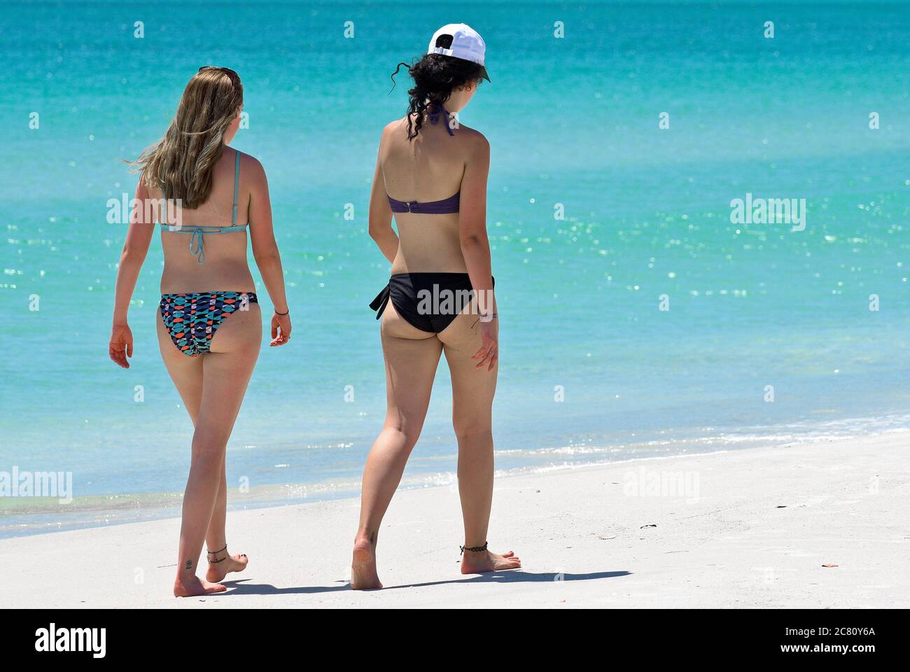 HOLMES BEACH, ANNA MARIA ISLAND, FL / USA - May 1, 2018: Two Young Women taking a leisure walk on the Beach enjoying a Beautiful Summer Day. Stock Photo
