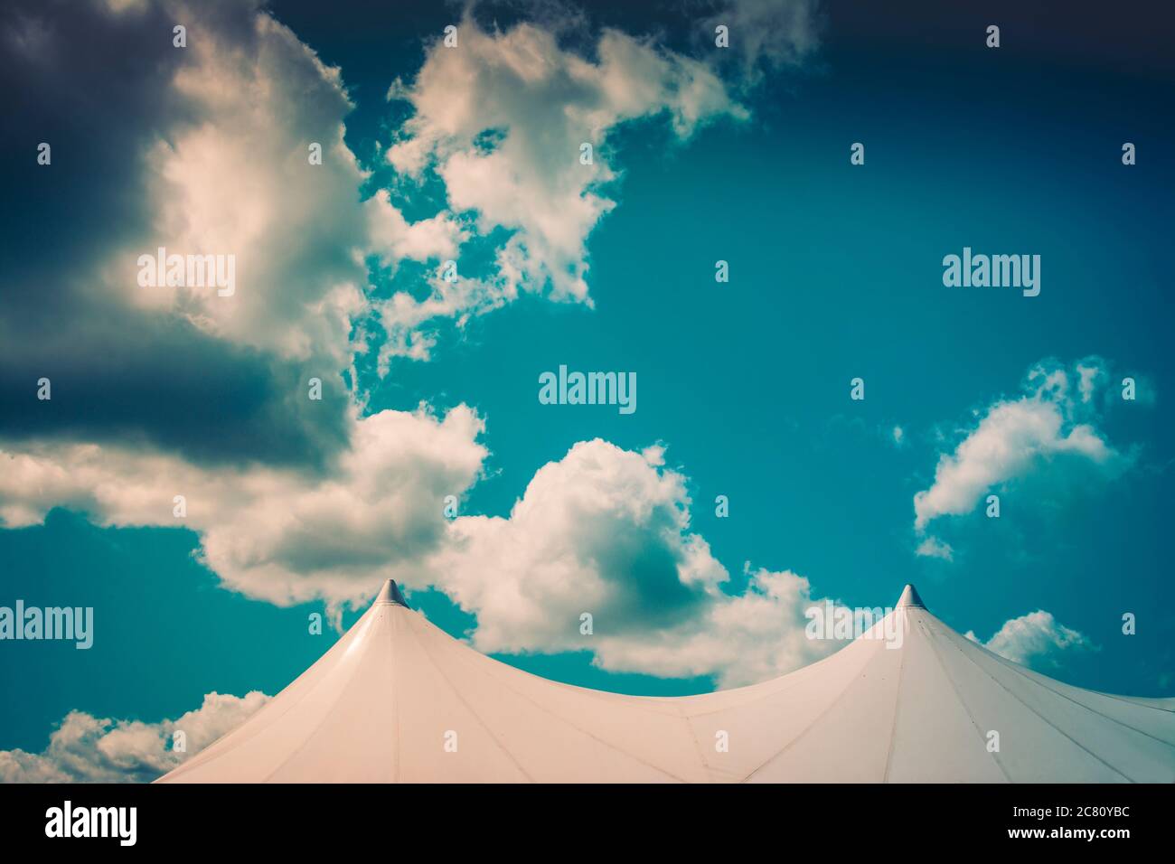 Clear blue sky with fluffy clouds above white tents during a sunny day ...
