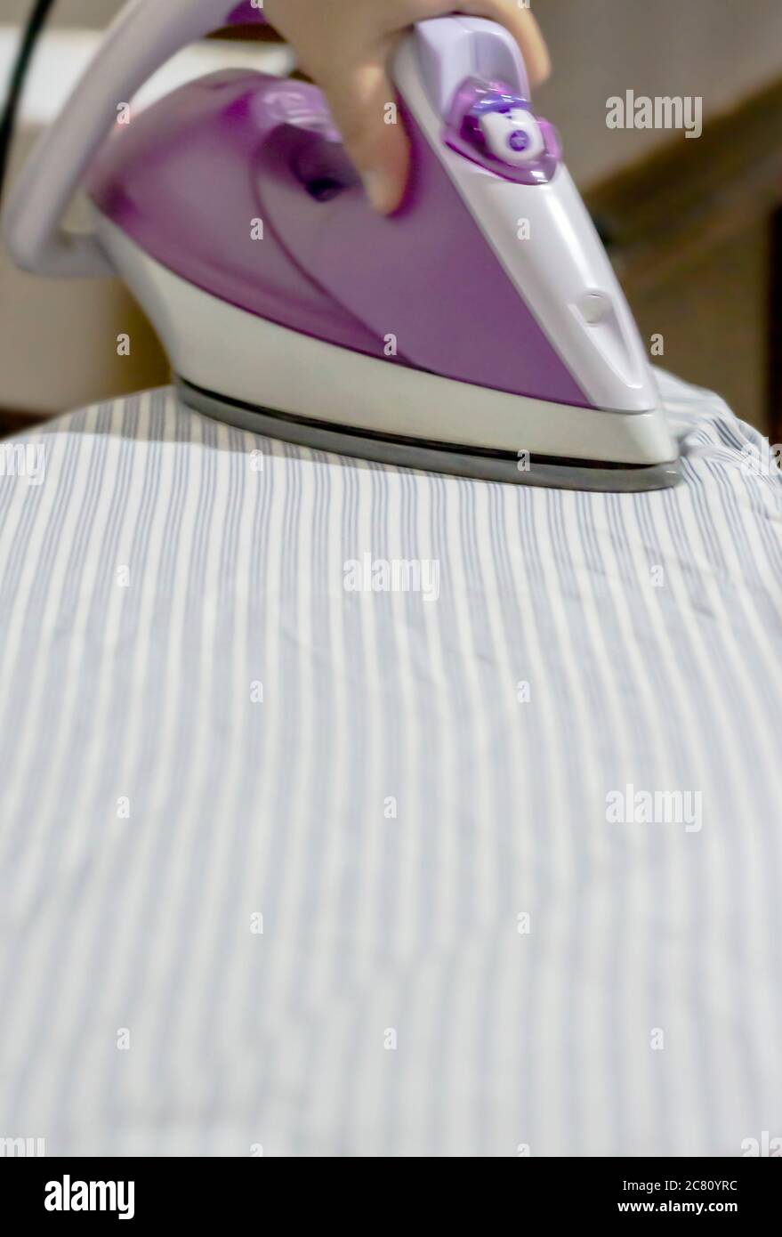 Ironing the clothes. Iron - Appliance, Laundry, Chores, Domestic Life, Wrinkled Stock Photo