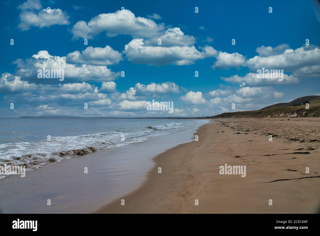 Beautiful view of a sandy beach under the blue sky with fluffy clouds ...