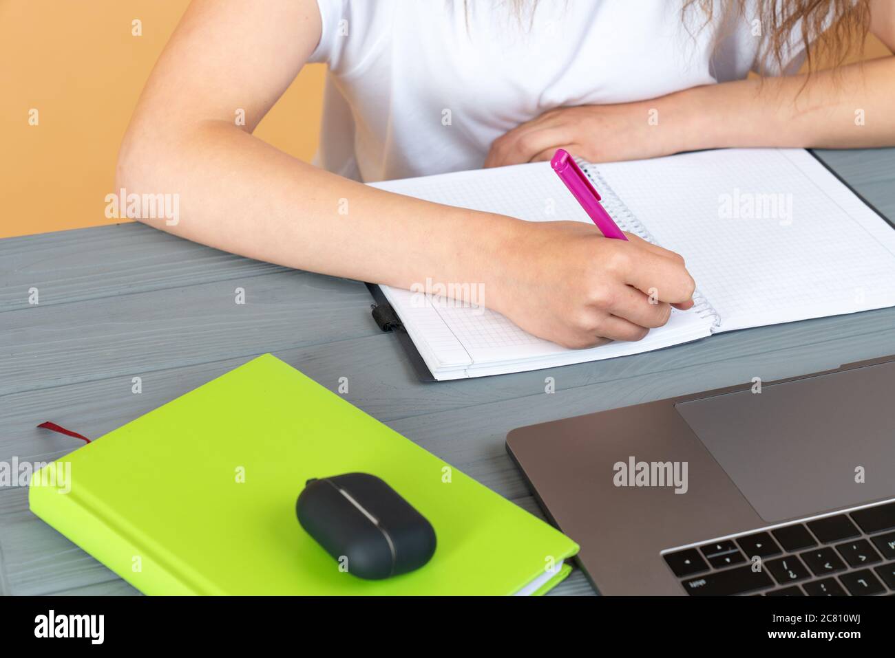 Close up of a woman hand writing in an agenda on a desk at home or office Stock Photo