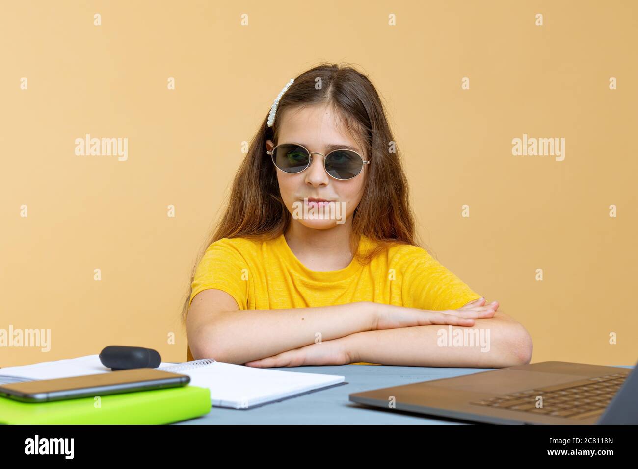 Focused young european girl businesswoman in sunglasses or student looking at the camera, serious black teen working or studying with computer doing Stock Photo