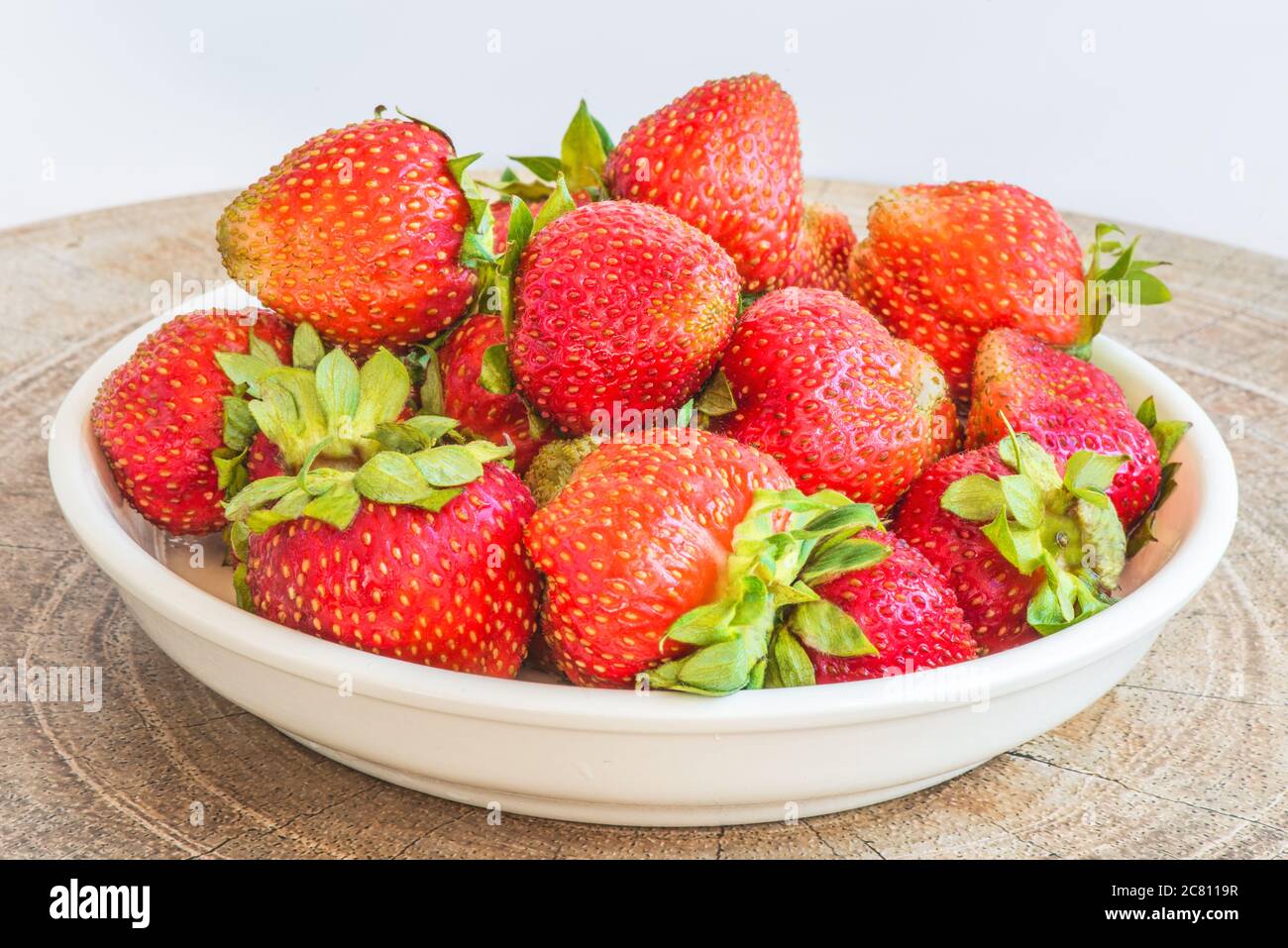 Strawberries in a plate on the table on a white background Stock Photo ...