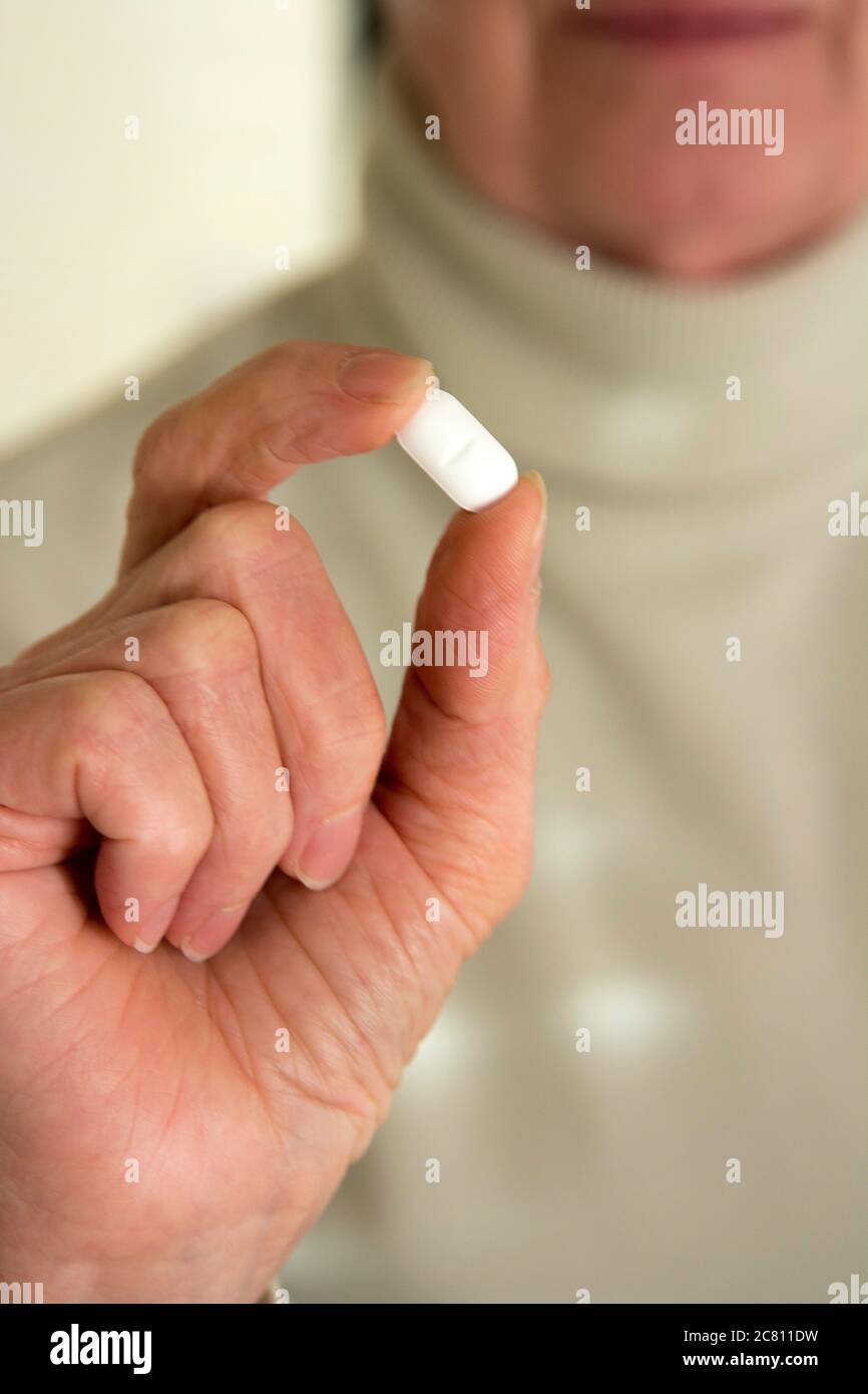 Woman holding medication pill Stock Photo