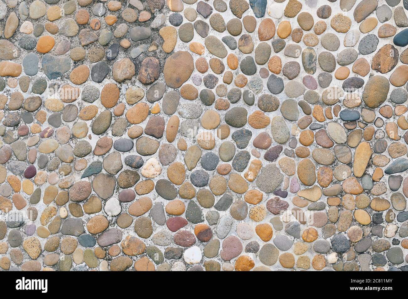 gravel stone wall texture background small stones that have been eroded by water are used to decorate the wall. Stock Photo