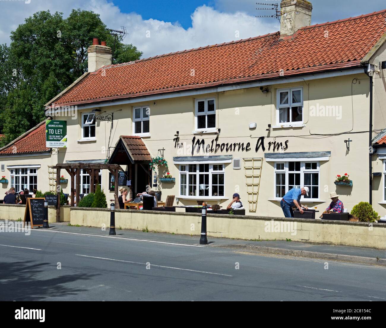 People enjoying a drink outside the Melbourne Arms, in the village of