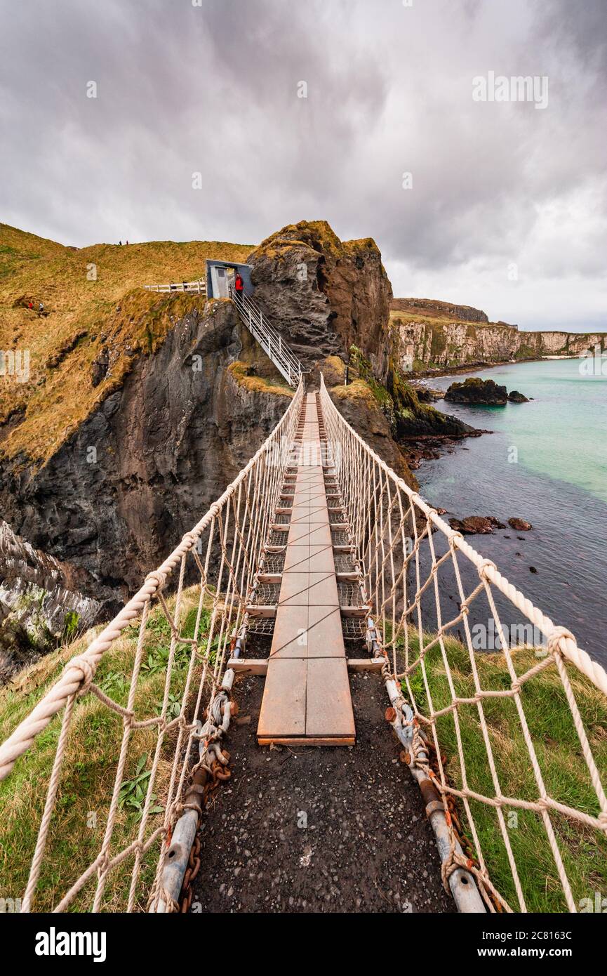 Carrick-a-Rede rope bridge between precipitous coastal cliffs on the Causeway Coast, Moyle County Antrim Northern Ireland Stock Photo