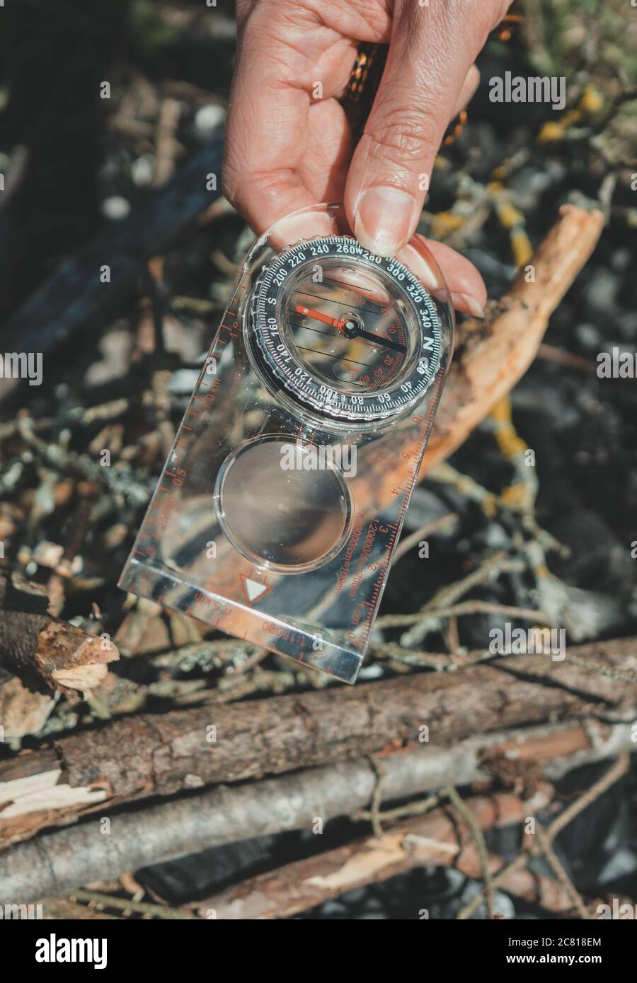 Woman uses a magnifying glass to burn a bonfire Stock Photo Alamy
