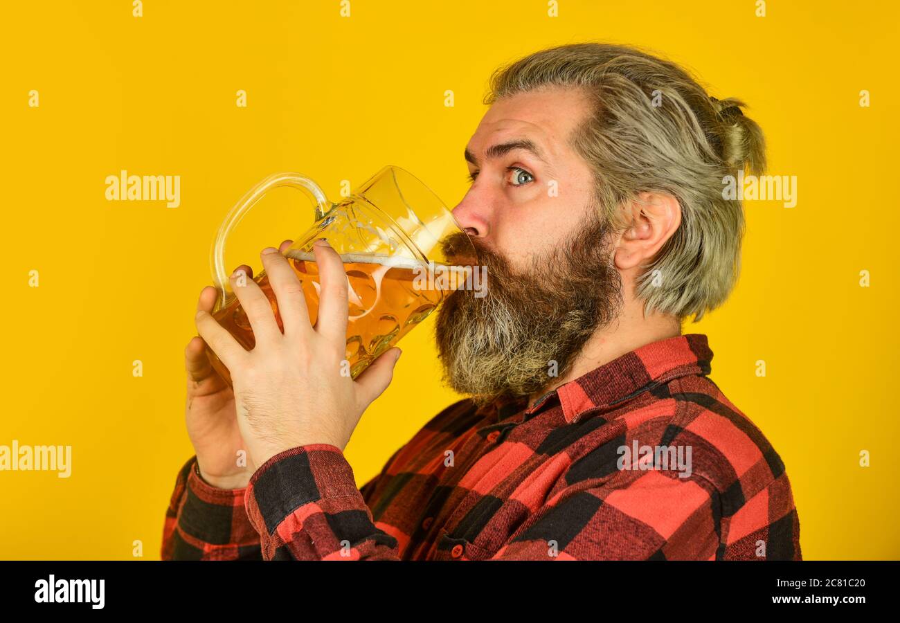 drink your beer. trying a new beer. brutal hipster drink beer. mature bearded man hold beer glass. mug of alcohol beverage. confident bartender. barman in bar. resting at pub. Cheers. sport bar. Stock Photo