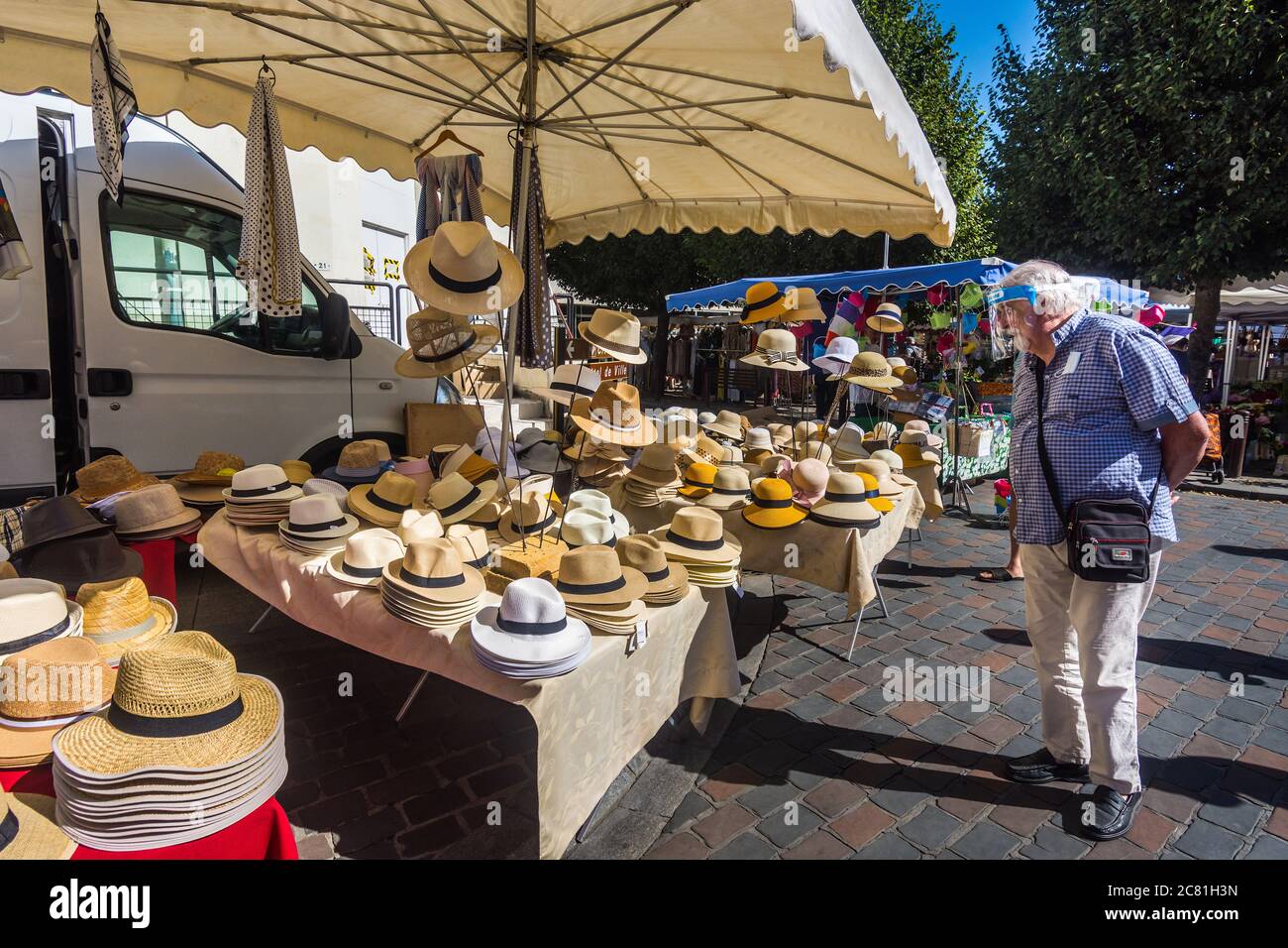 Man looking at straw hats in French open-air market - Loches, Indre-et-Loire, France. Stock Photo