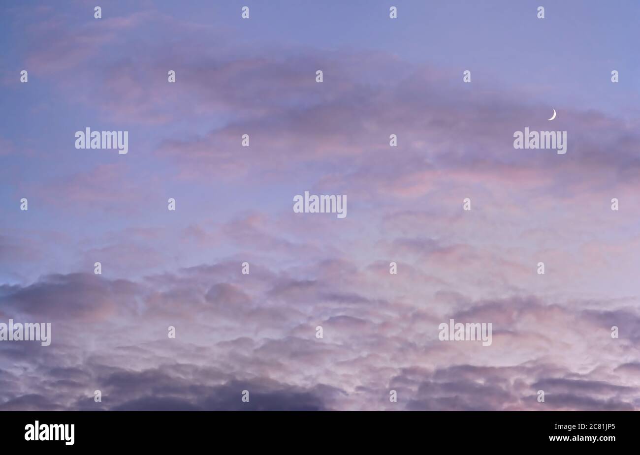 Evening purple sky with some barely visible clouds, moon crescent in right side - blue hour background Stock Photo