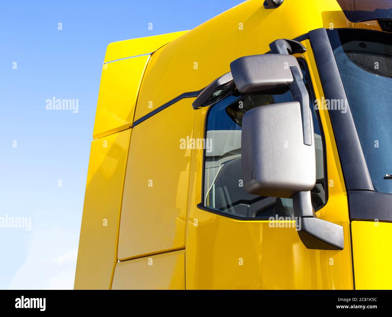 modern, streamlined truck cab with good aerodynamics with a rearview mirror. Yellow truck cab, technology Stock Photo