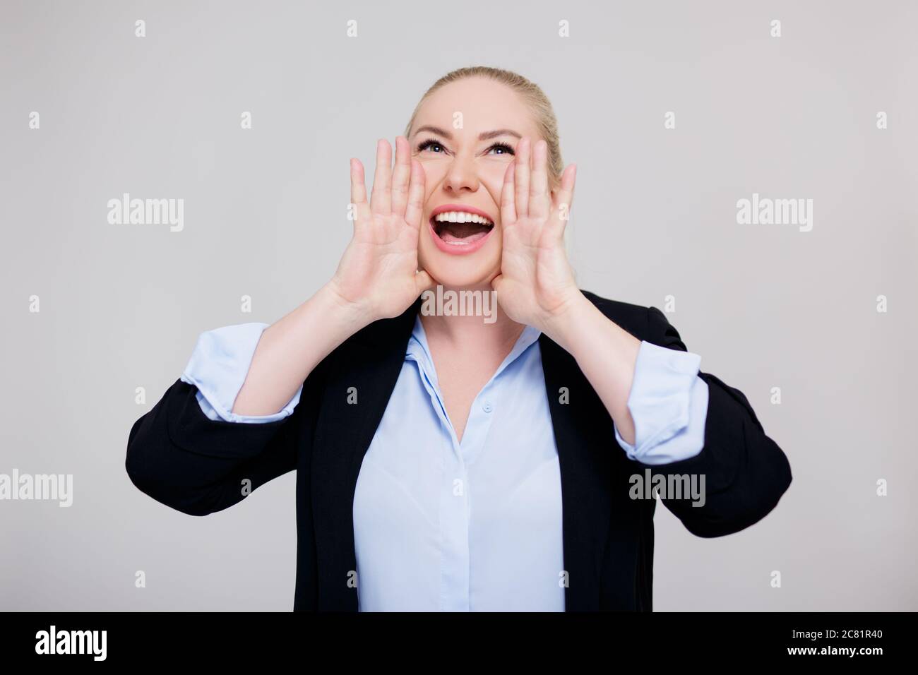 announcement or advertisement concept - happy blonde woman screaming about something over gray background Stock Photo