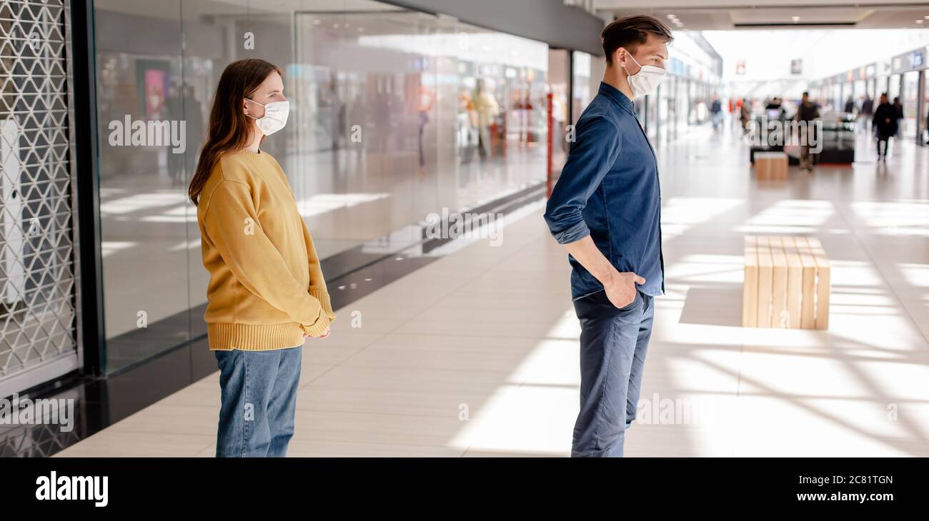man and a woman standing in a supermarket at a safe distance. Stock Photo