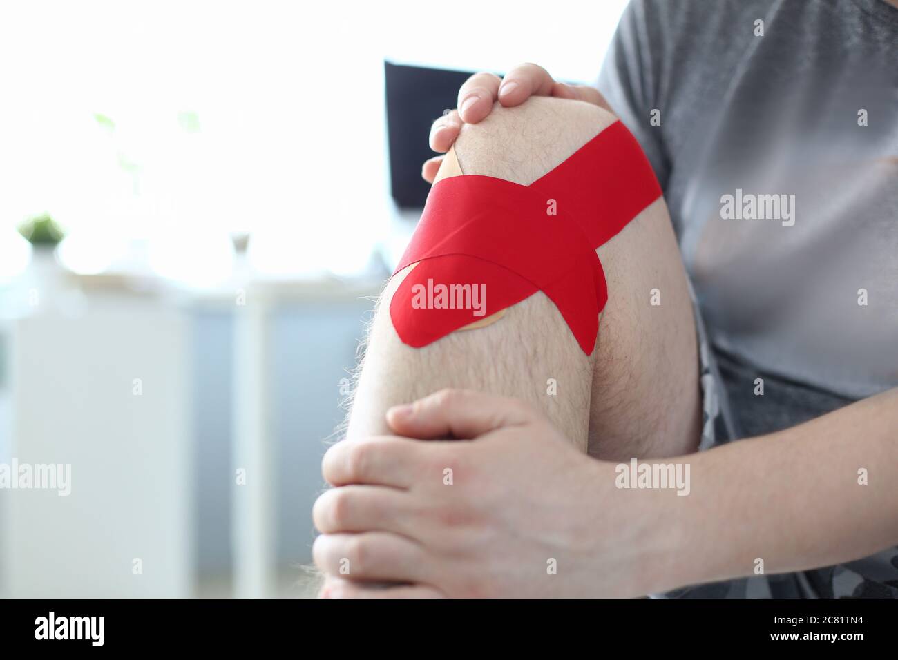 Man with hurt knee using medical taping for treatment Stock Photo Alamy