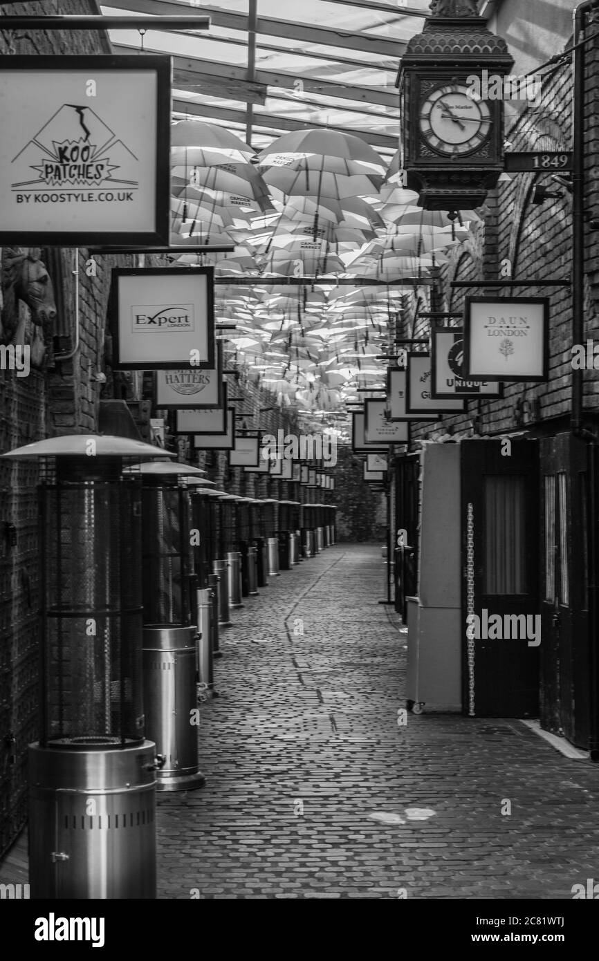 Black and white image of umbrellas hanging in the famous Camden Stables