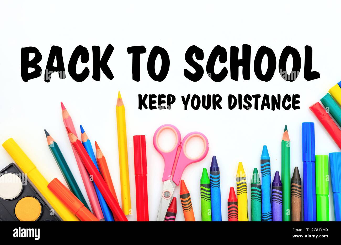 BACK TO SCHOOL KEEP YOUR DISTANCE text message and school supplies on white background, Coronavirus spread in school prevention measure Stock Photo