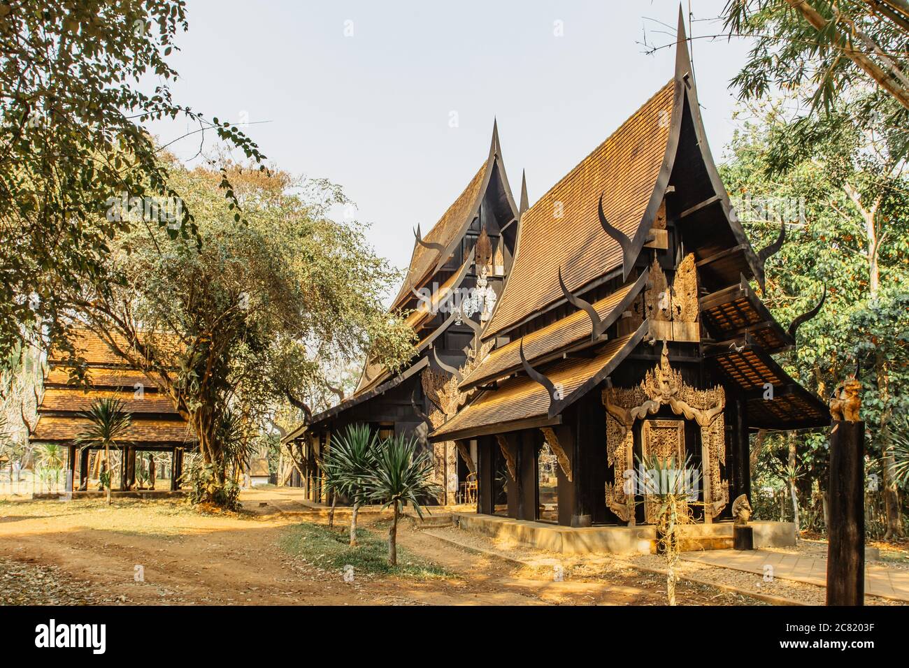 Black Temple in Chiang Rai,Thailand.Popular tourist place.Wooden house gold facade.Carved painted wood.Thai style house decor.Thai lifestyle Stock Photo