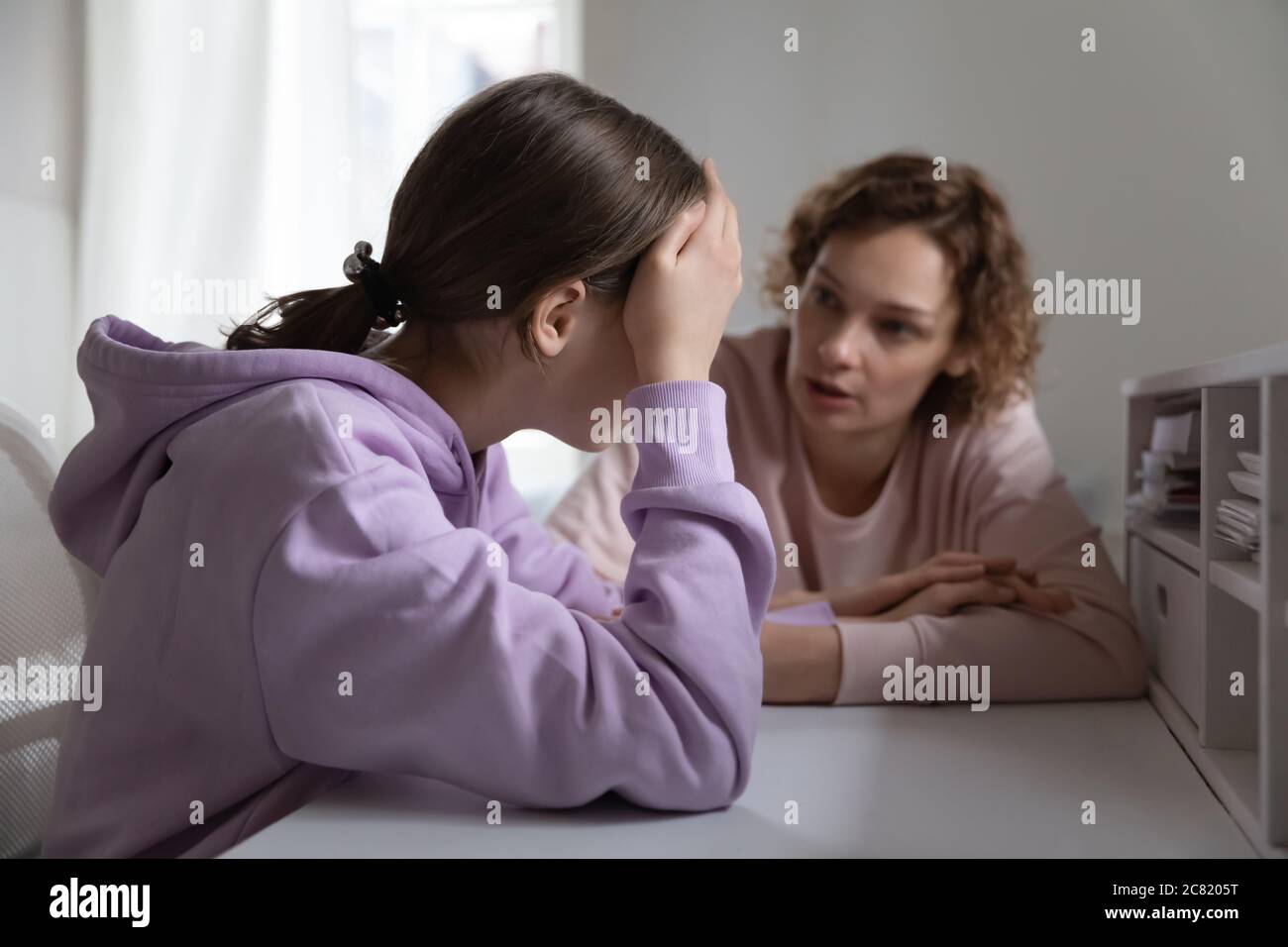 Strict angry mother scolding teenage daughter for bad exam results Stock Photo