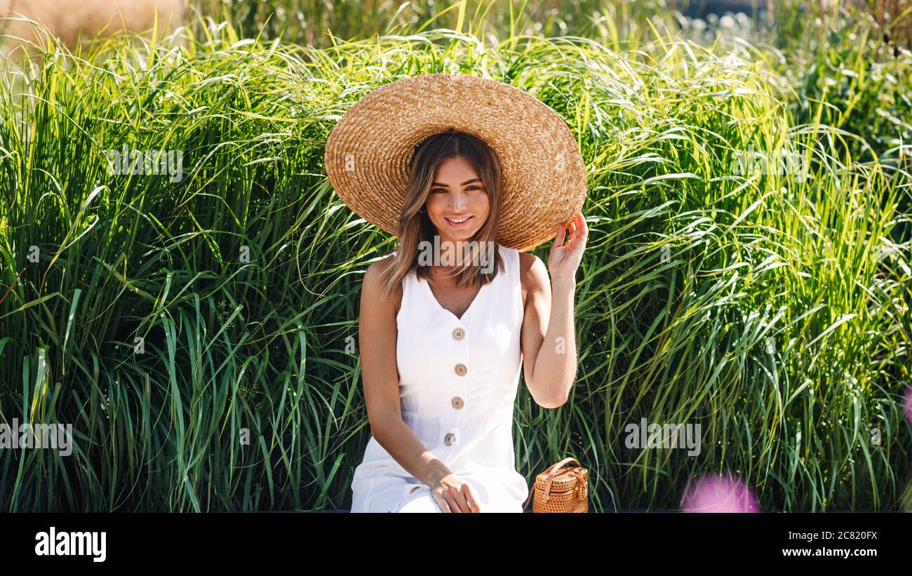 Woman holding sun hat hi-res stock photography and images - Alamy