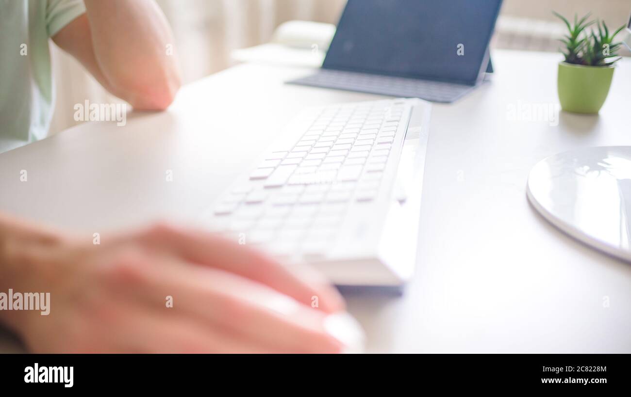 the developer works at the computer, typing, uses the mouse. Selective focus Stock Photo