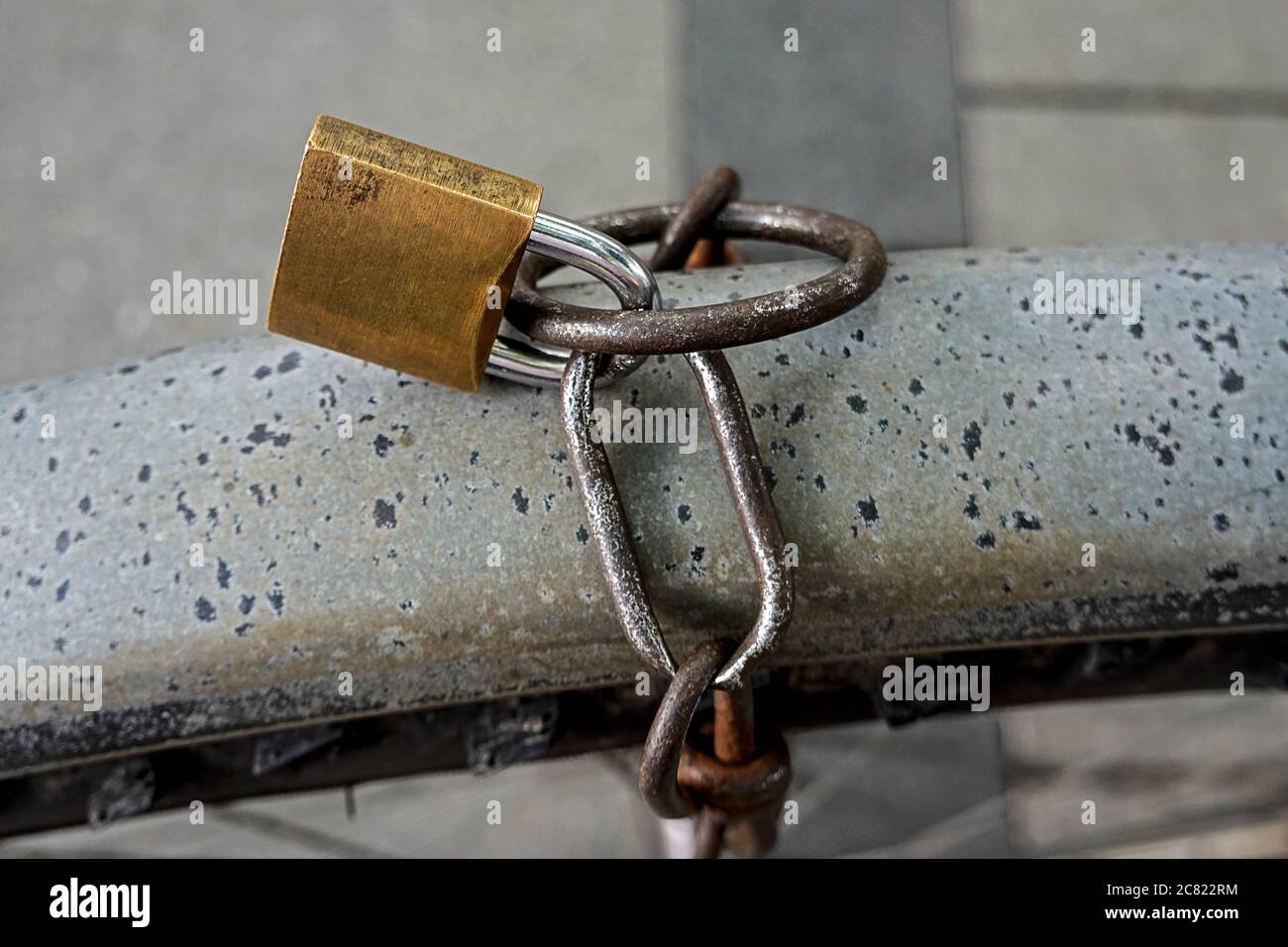 close up of a golden colred lock with rusty chain Stock Photo